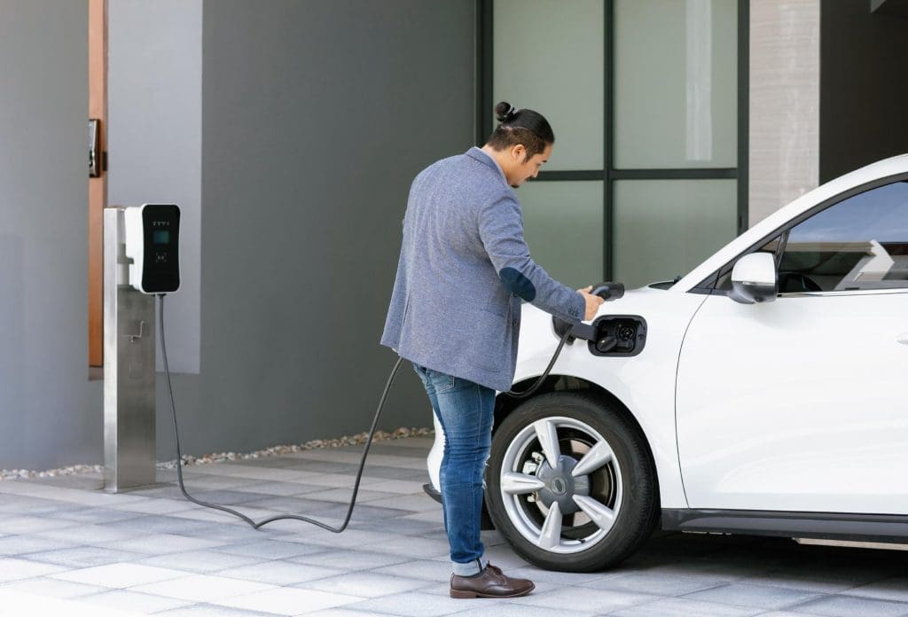 man pumping gas into a car at a gas station, highlighting the contrast with EV grants and incentives in Ireland
