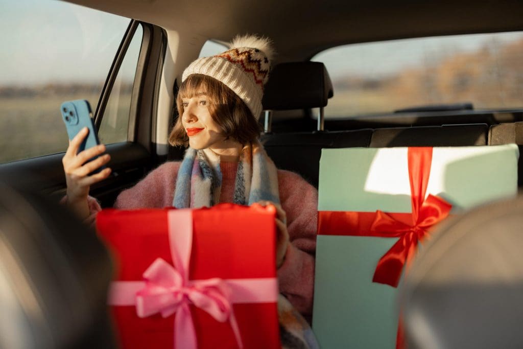 woman sitting in the back seat of a car holding a cell phone