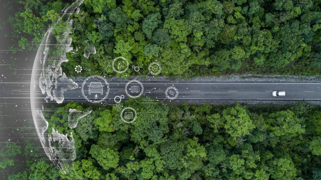 aerial view of a road in the middle of a forest showcasing the potential for EV silent driving