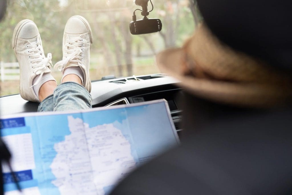 person sitting in a car during an EV road trip in the UK with their feet on the dashboard