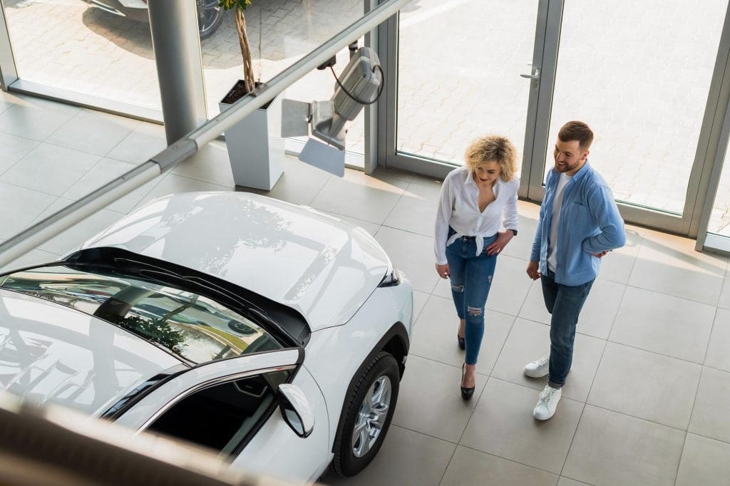man and a woman walking towards a car to hire an electric vehicle in the UK
