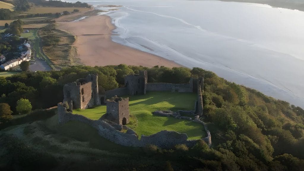 aerial view of a castle near the ocean with EV charging in Wales