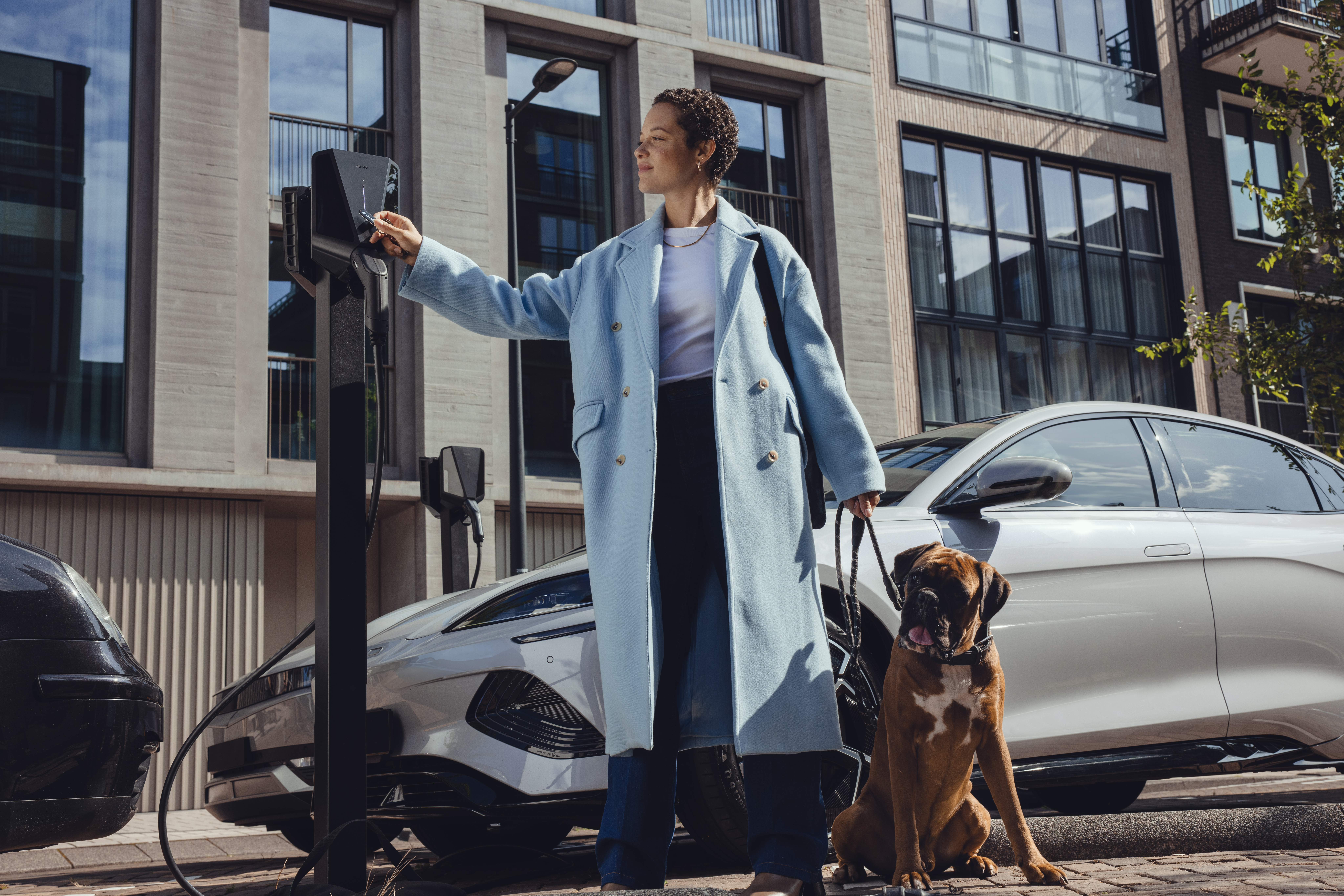 woman standing next to a dog next to a parking meter