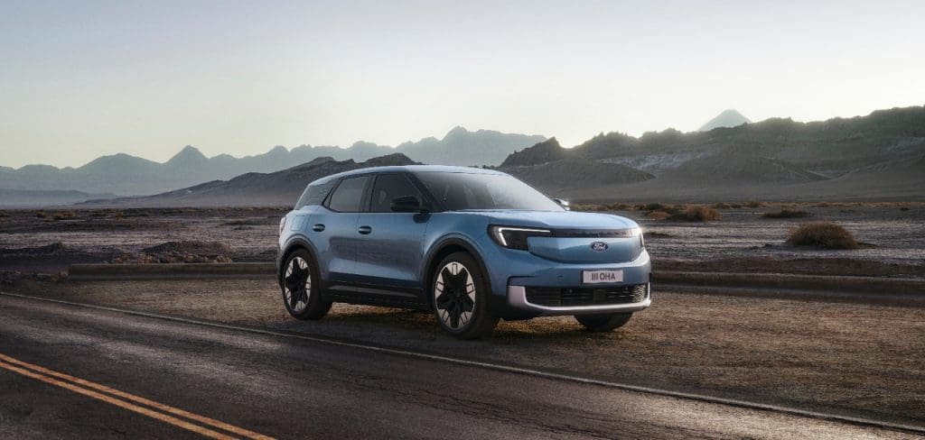 blue car driving down a desert road