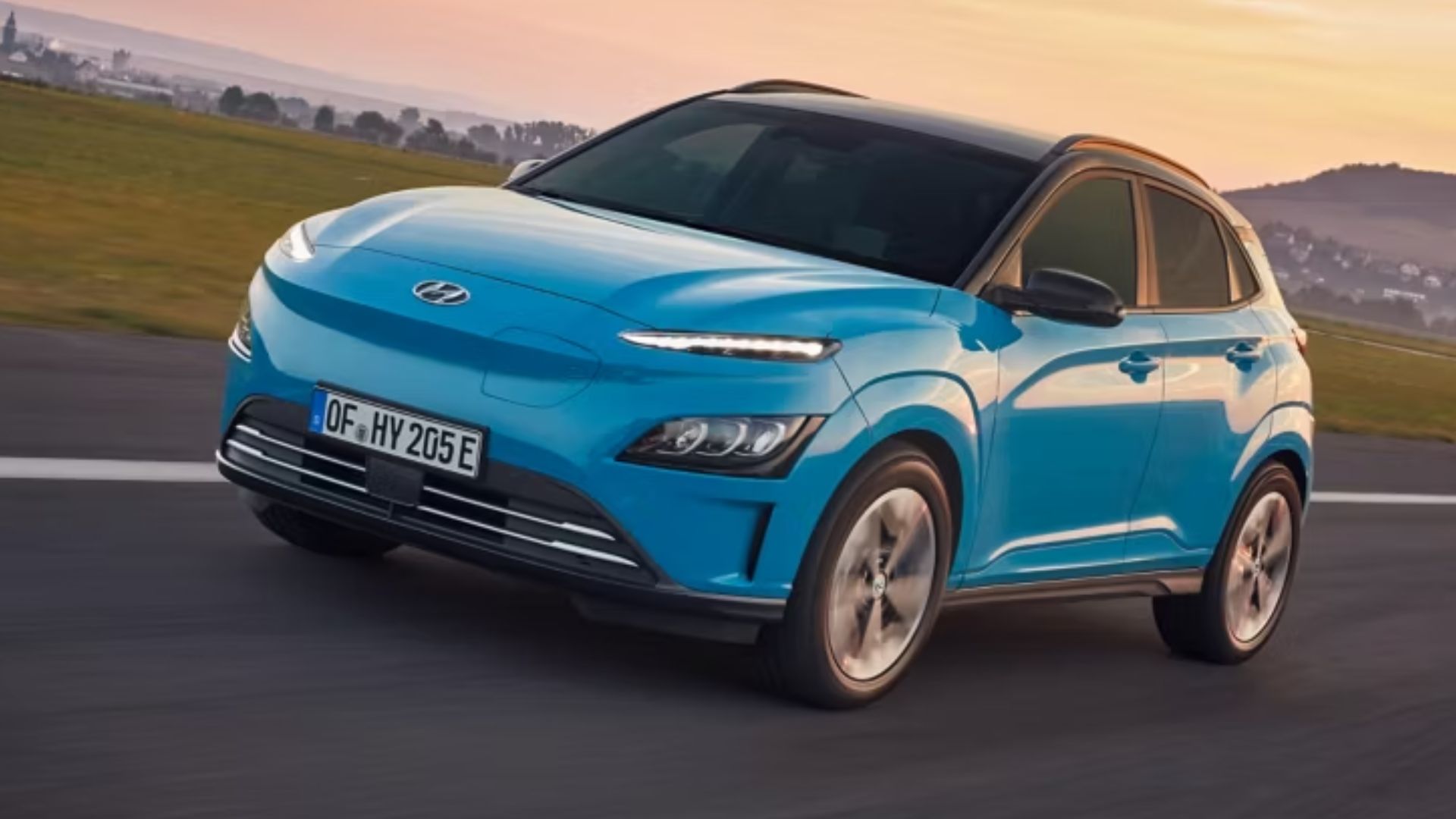 Hyundai Kona Electric blue SUV driving on a UK countryside road