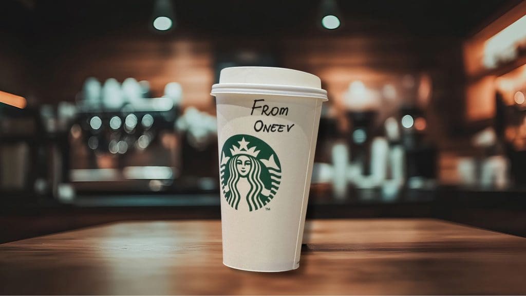 Starbucks cup sitting on top of a wooden table